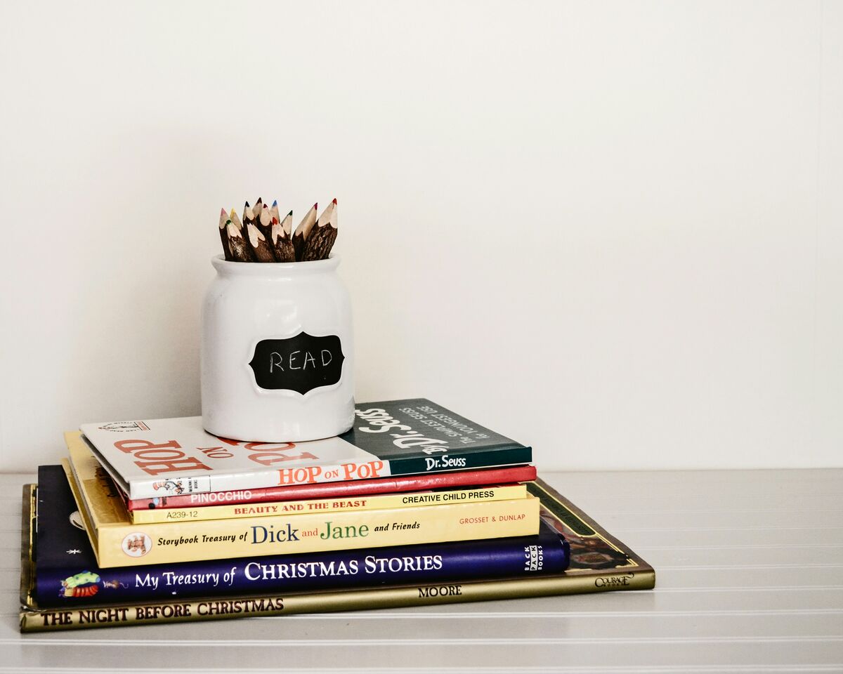 A stack of books beside a jar labeled read