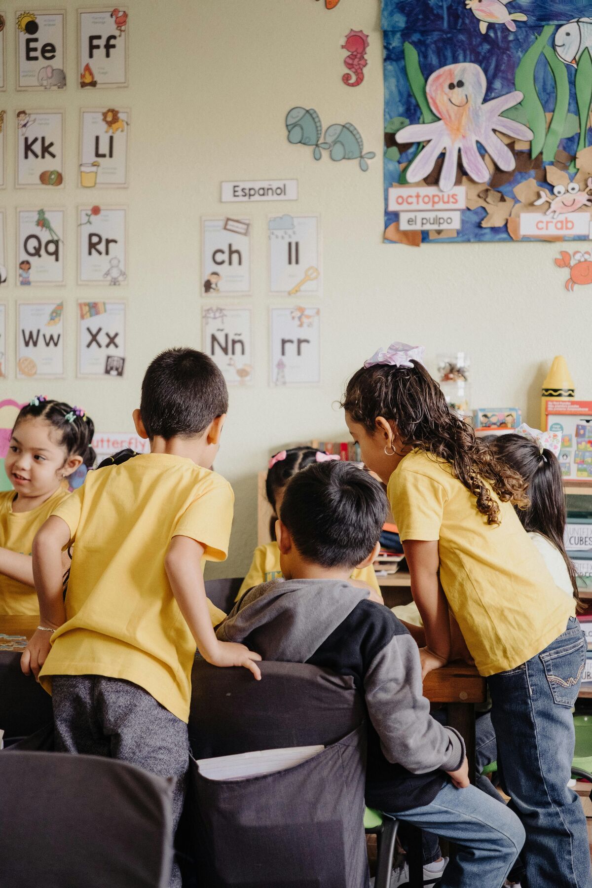 Students learning near an alphabet wall