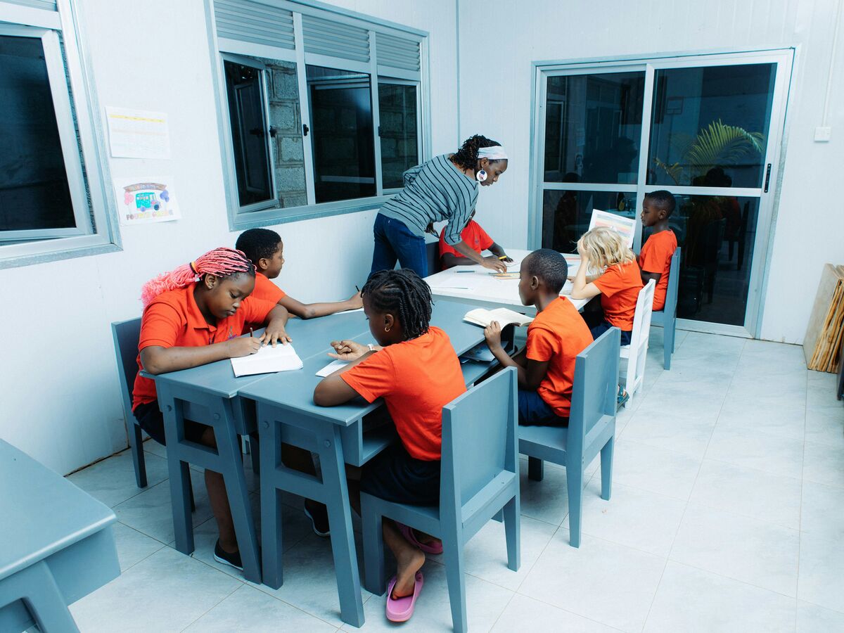 A teacher working with young students at a classroom table