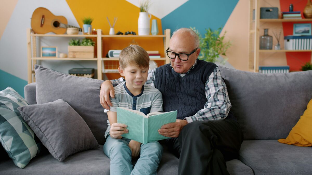 A parent reading on the couch with her young daughter